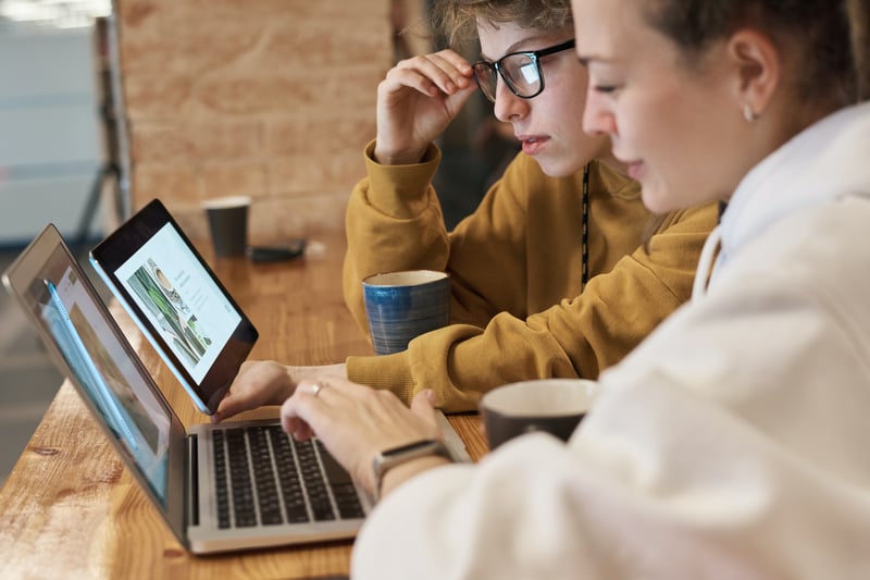 People Looking at a Laptop and a Tablet